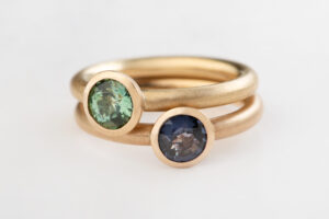 Solitaire Ringe. Blauer Spinell und grüner Turmalin in Schalenfassung, Gold